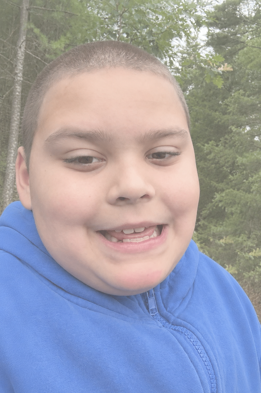 Rocco smiling outdoors in a blue jacket